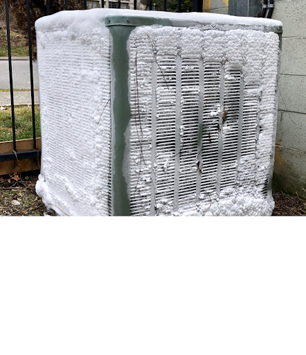A white air conditioner covered in snow and ice.