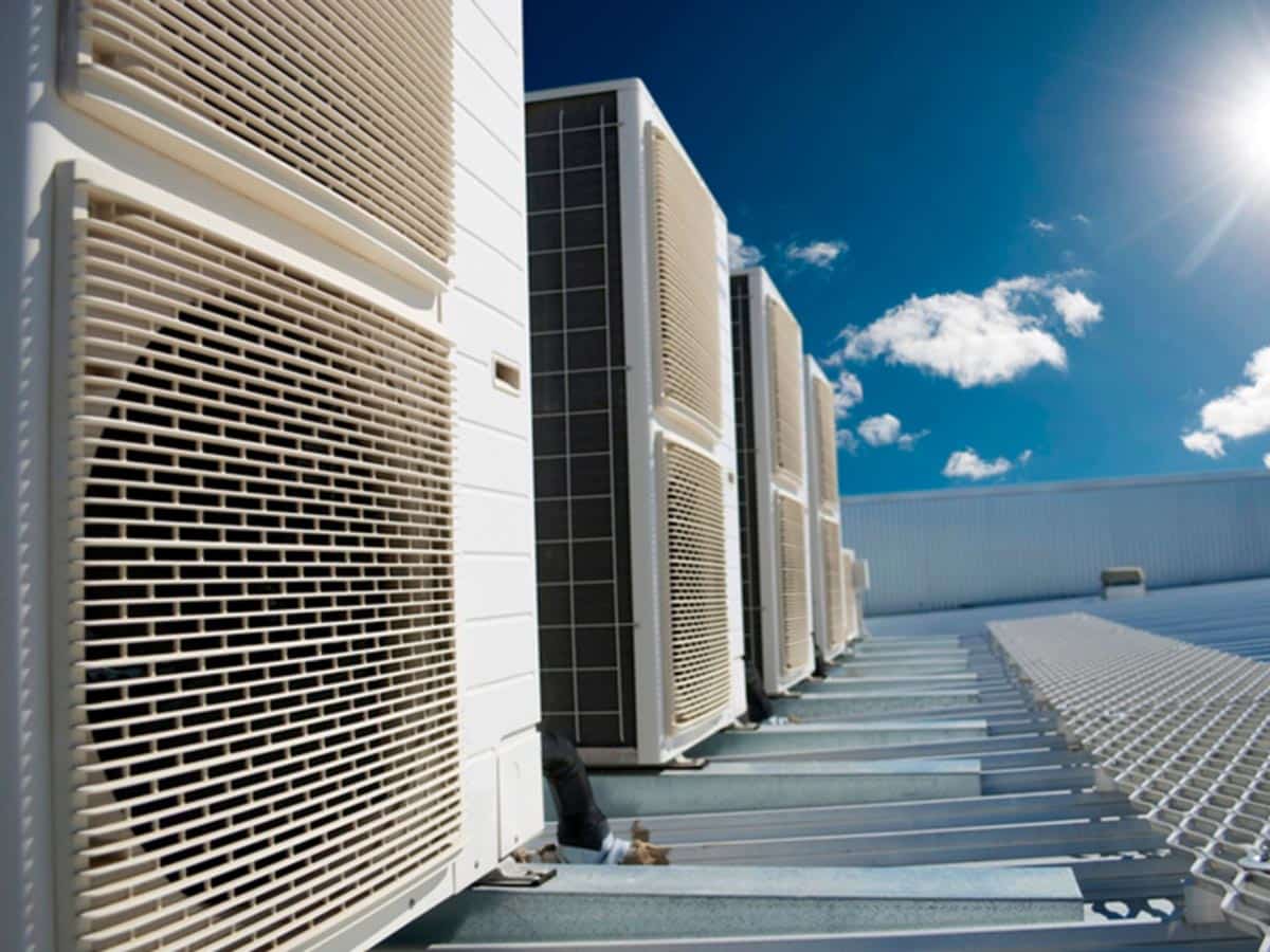 A row of air conditioners on the side of a building.