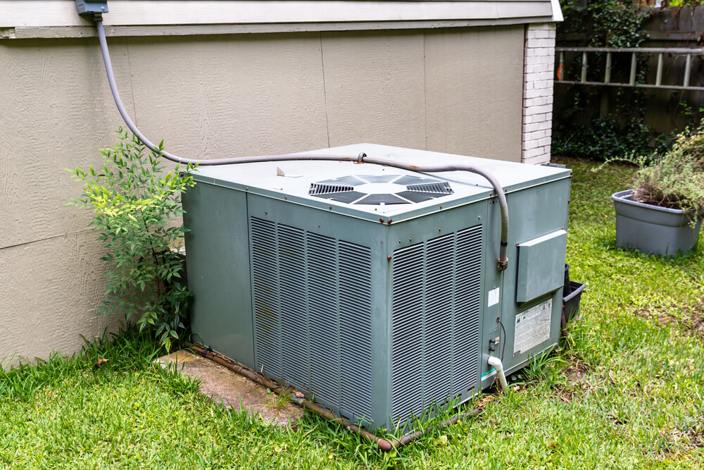 A large air conditioner sitting outside of a house.